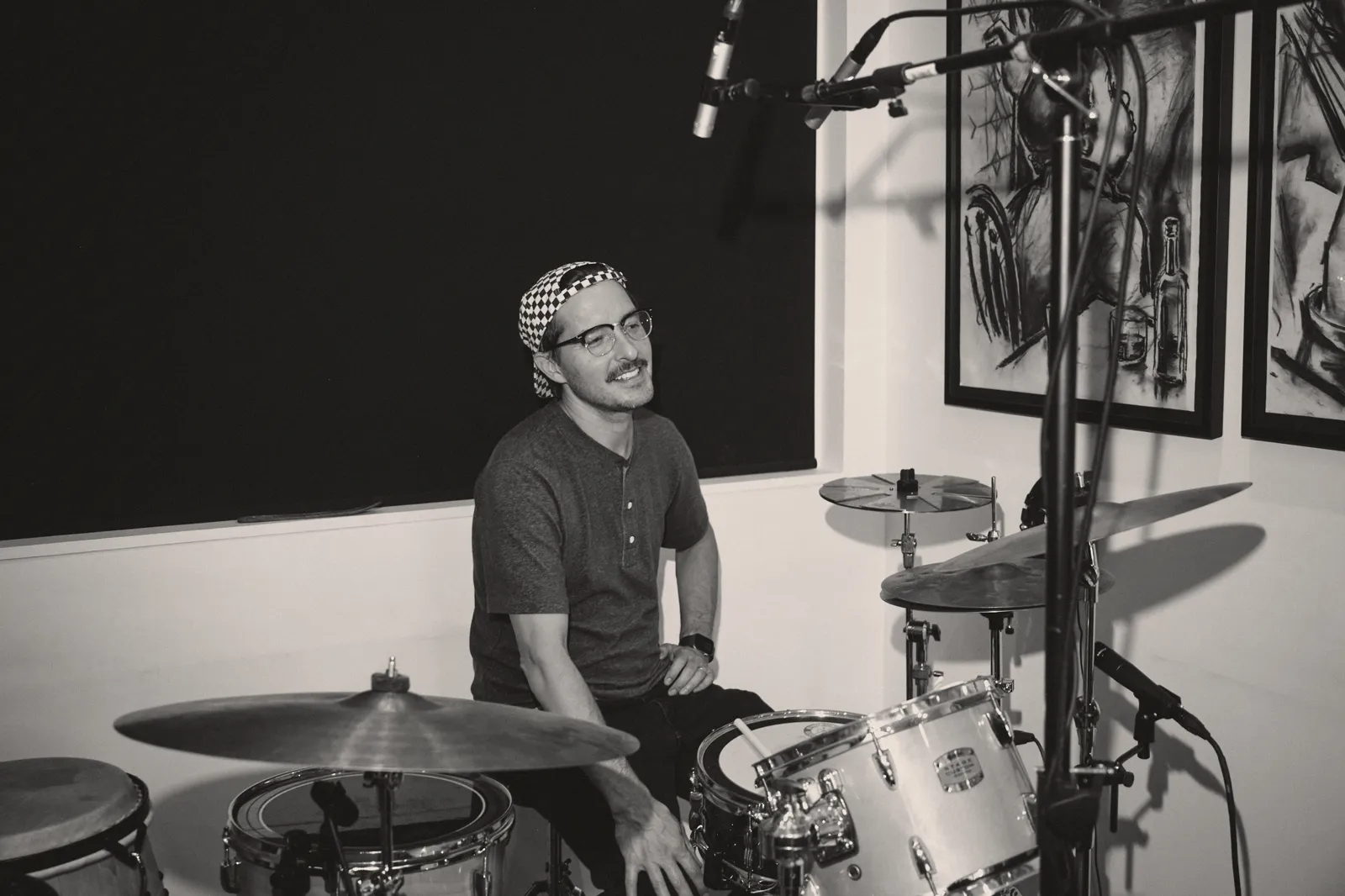 Black-and-white photo of Graham Hill behind the drum kit in the studio