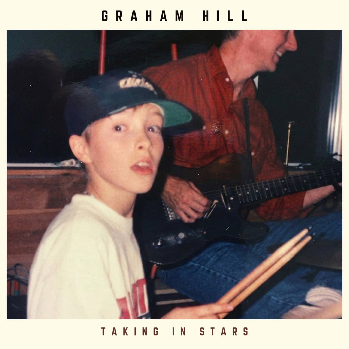 Taking In Stars album cover: young Graham Hill with drumsticks, his father on guitar behind him